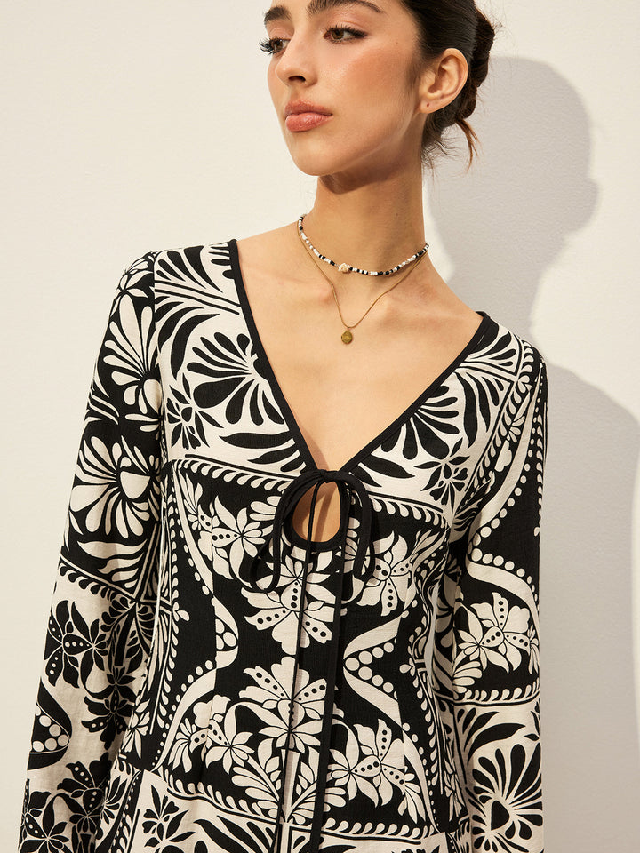 Bedrucktes Kleid mit Glockenärmeln und Bindung vorne