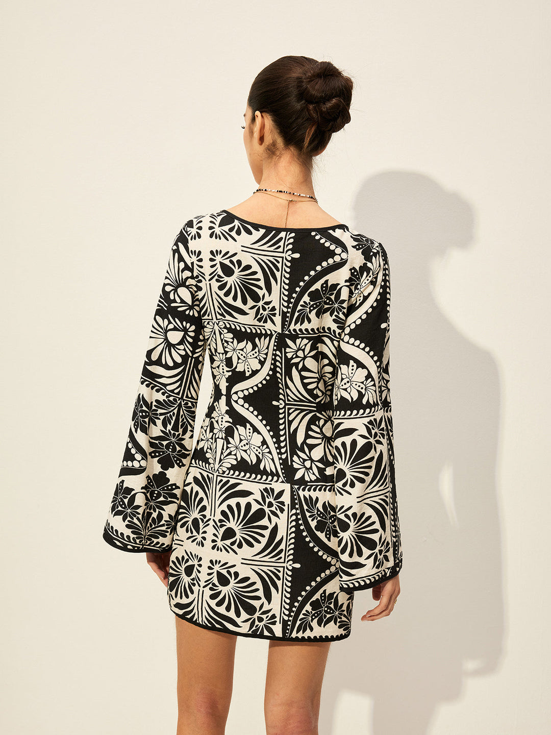 Bedrucktes Kleid mit Glockenärmeln und Bindung vorne