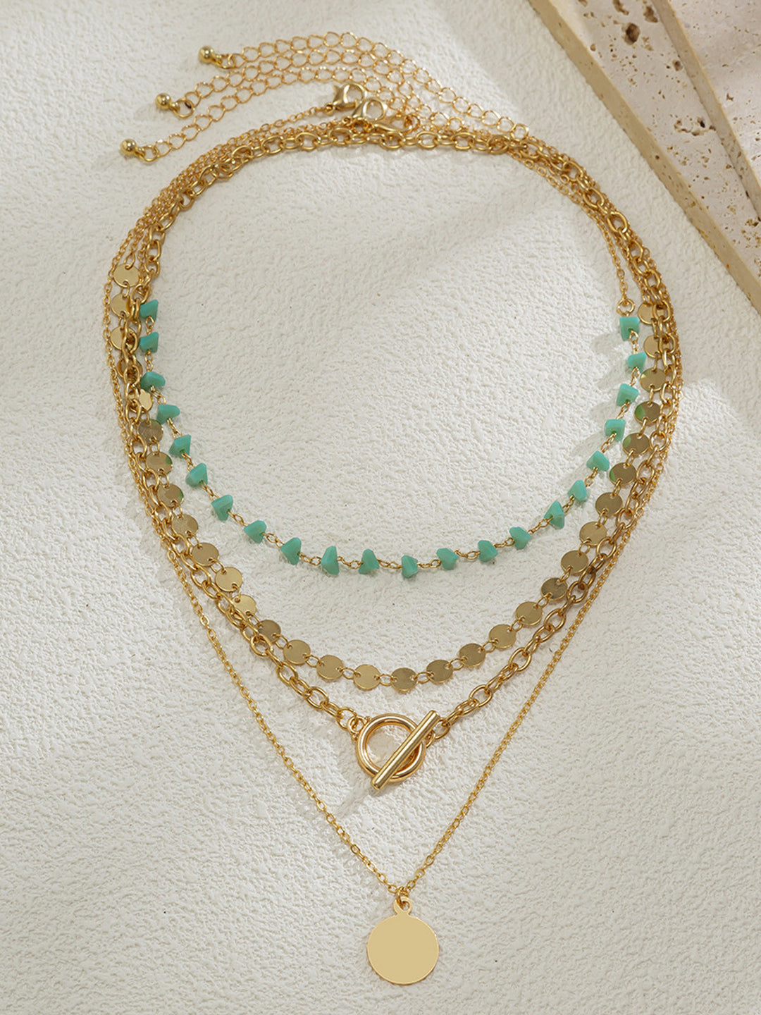 Mehrschichtige Goldkette mit Türkisperlen und Kreispendant